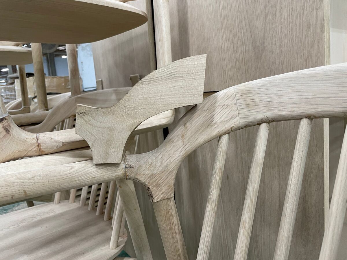 A new profile cut in oak, held against the chair to compare it with the original