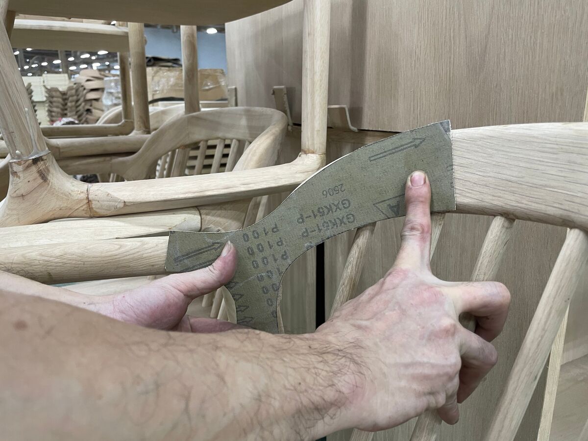 Hands fitting a template of the new profile onto the chair frame