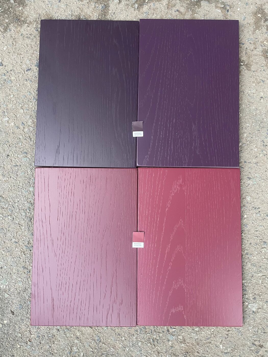 Four stained oak color samples laid next to the customer's Pantone chips