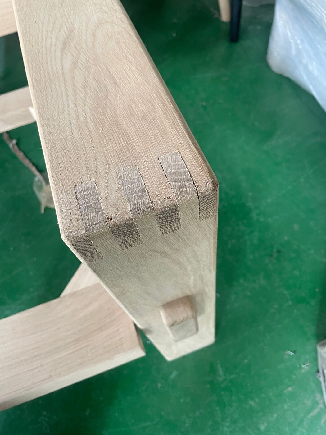 Close-up of the finger joint between the armrest and leg of an oak lounge chair