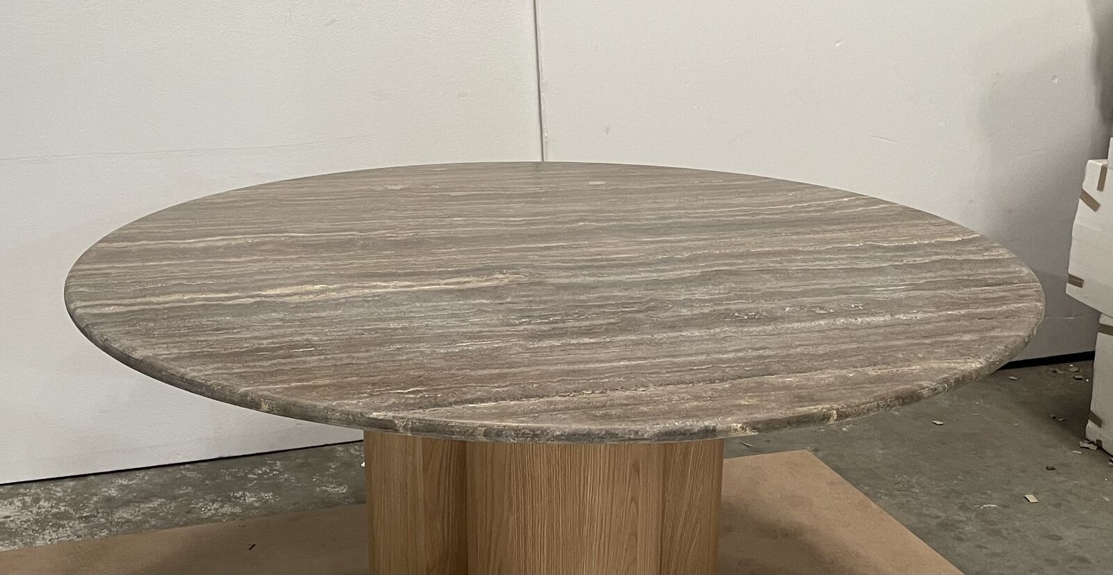 Round dining table with a travertine top on an oak pedestal base